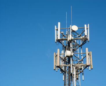 medium shot of a cell tower against a clear blue sky