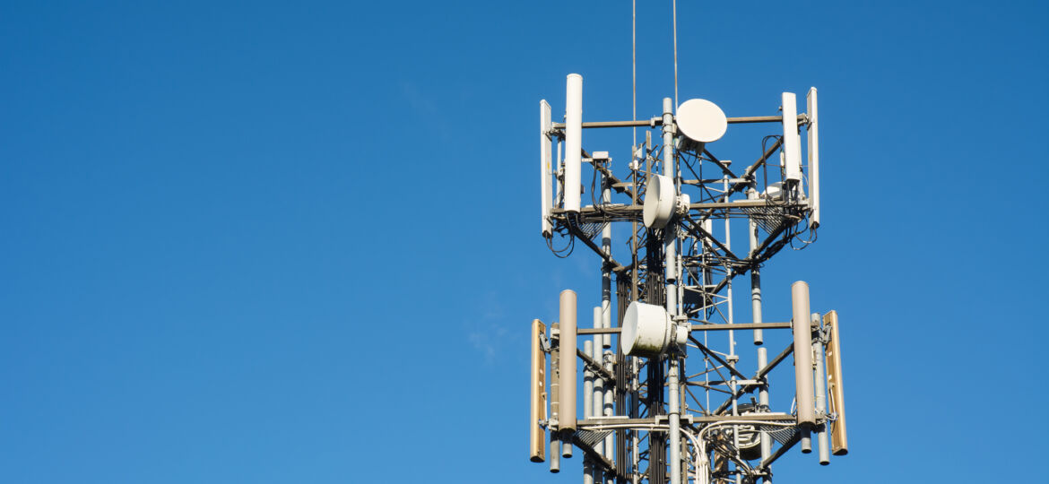 medium shot of a cell tower against a clear blue sky