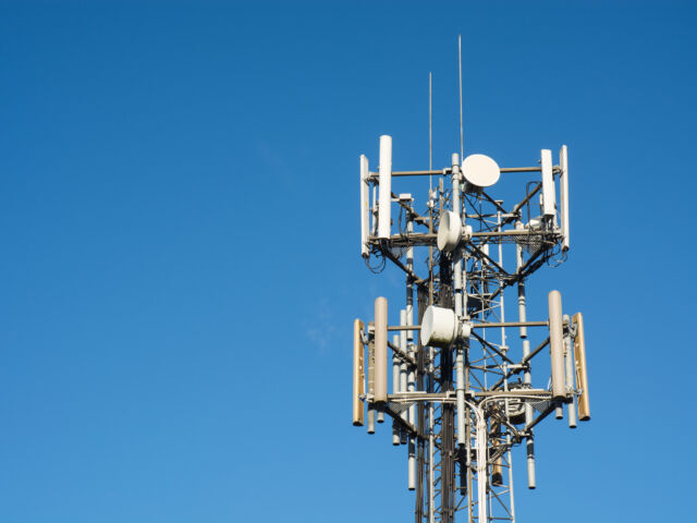 medium shot of a cell tower against a clear blue sky