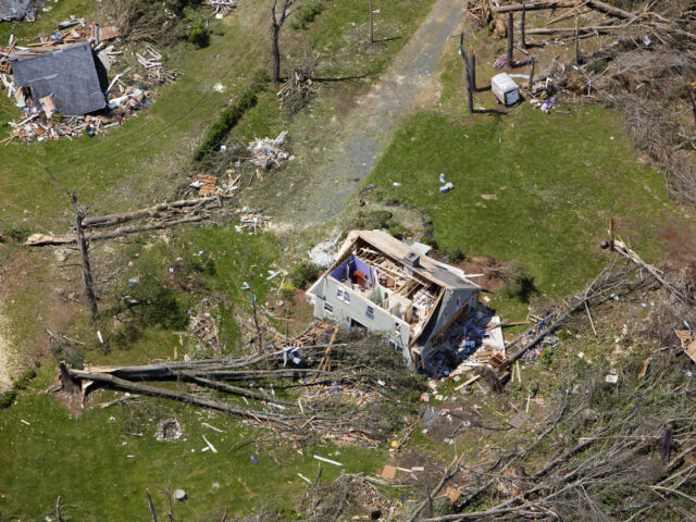 aerial image of a damaged home surrounded by fallen trees after hurricane